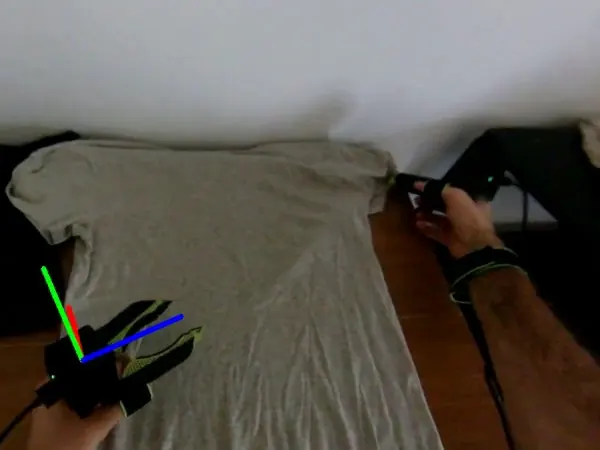Derived pose axes drawn on the left gripper while it aligns a grey shirt